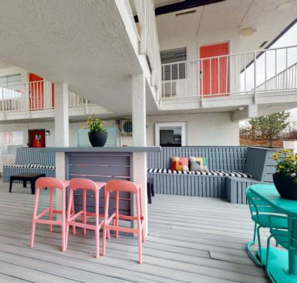 A white building with a balcony and a table with chairs.