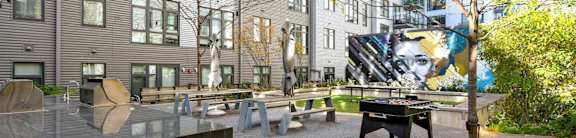 A courtyard with a bench and a table in front of a building.
