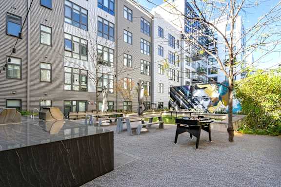 A courtyard with a bench and a table in front of a building.
