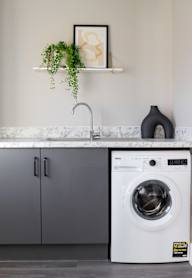 a modern kitchen with grey cabinets and black appliances