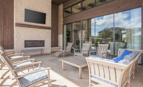 a patio with a tv and chairs at Ovation at Lewisville Apartments, Texas , 75067