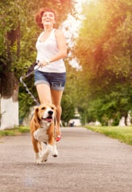 Woman Smiling while Jogging with Dog