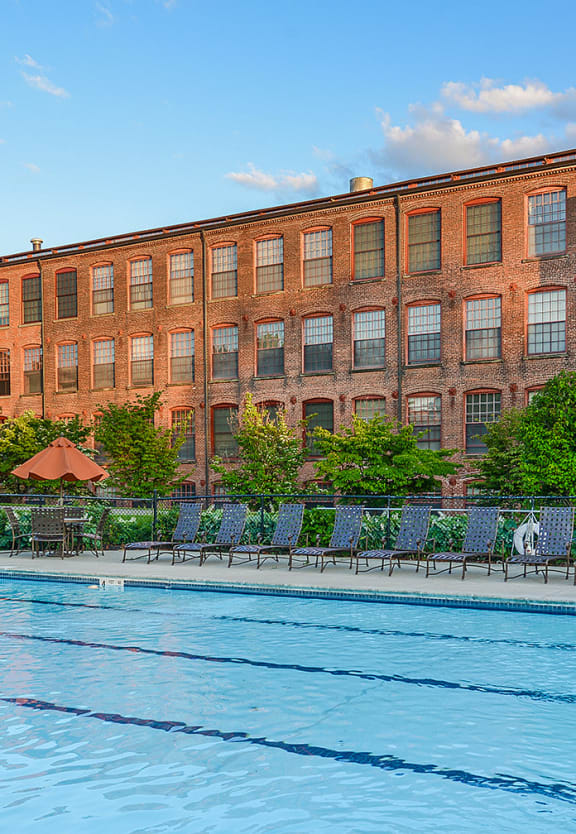 a brick building with a large pool in front of it