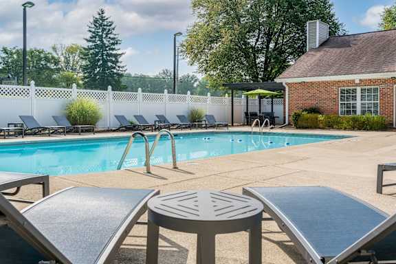 A large swimming pool surrounded by lounge chairs and umbrellas.