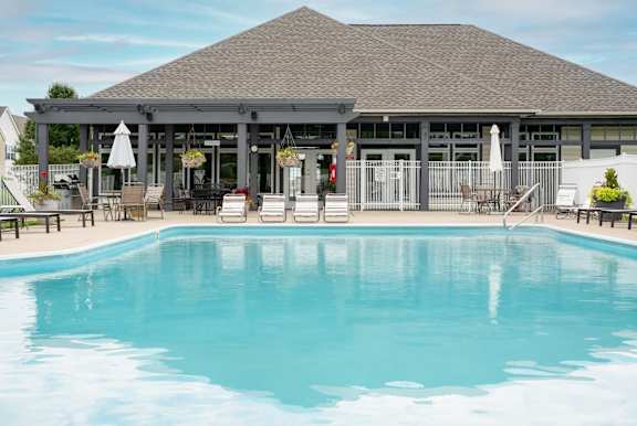 A large swimming pool surrounded by lounge chairs and umbrellas.