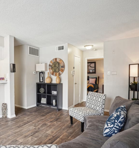 Model A2 floor plan living room with a couch a chair and view of the kitchen Noel on The Parkway in Dallas, TX