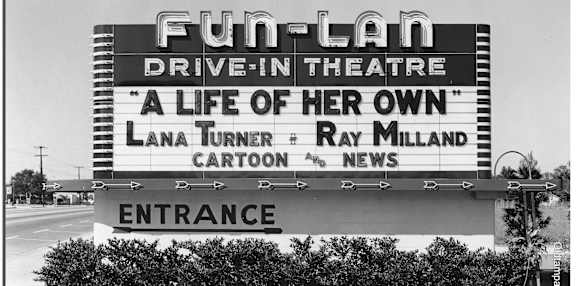 A black and white photo of a Fun-Lan Drive-In Theatre sign.