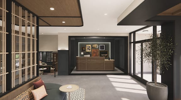 A modern office lobby with a reception desk and a large window.