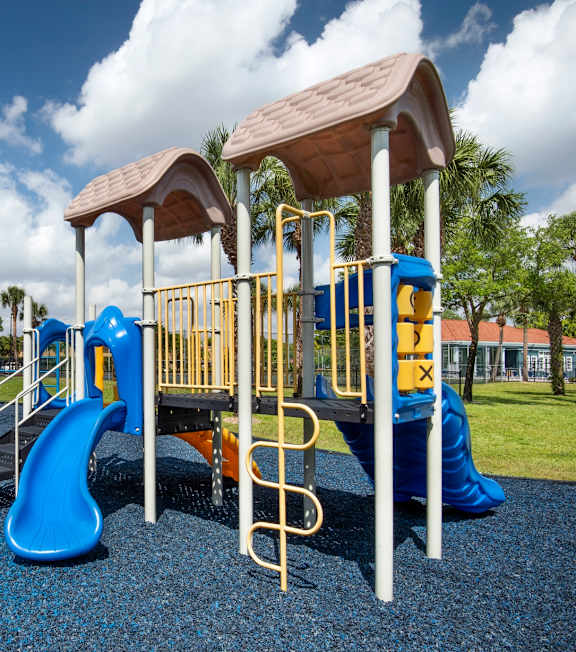A playground with a blue slide and yellow railings.