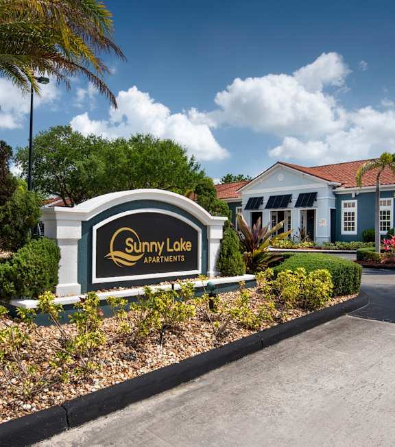 A Sunny Lake Apartments sign is in front of a building.