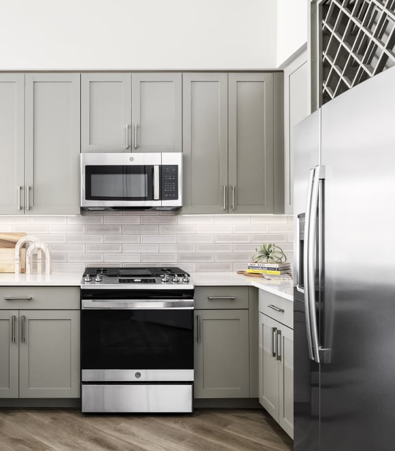 a kitchen with stainless steel appliances and white cabinets at The Ivy, Chatham, NJ