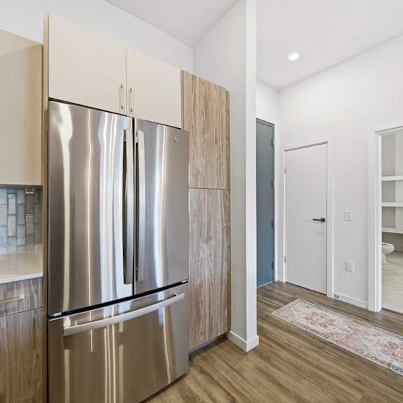 A kitchen with a white counter top and a stainless steel refrigerator.