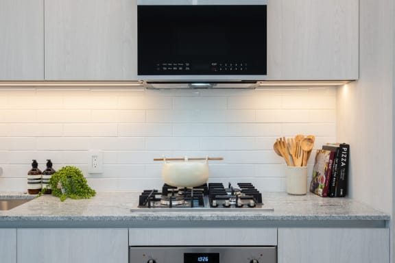 a white kitchen with a stove and a tv above it