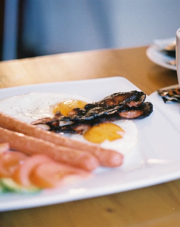 a plate of food on a table with a cup of coffee
