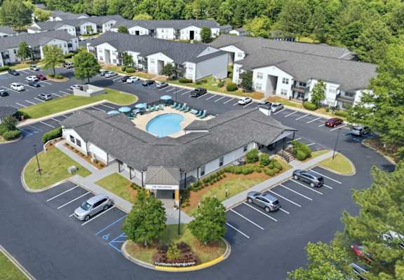 A large building with a pool in the middle of a parking lot.