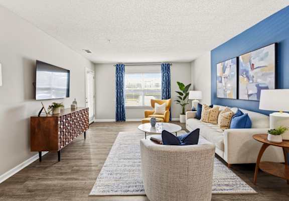 A living room with a white couch, a wooden cabinet, and a rug.