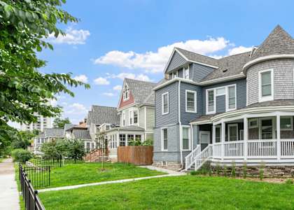 a house with a yard and a fence in front of it