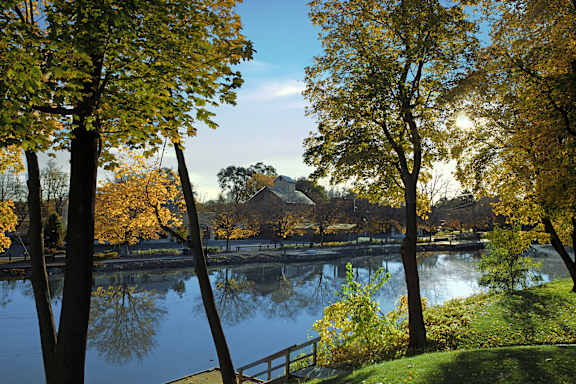 A serene lake surrounded by trees with autumn leaves.