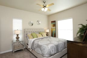 a bedroom with a bed and a ceiling fan