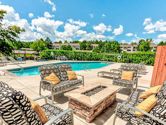 A poolside patio with a table and chairs.