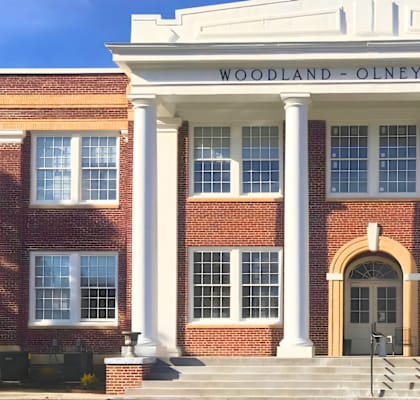 Woodland-Olney School building with a white entrance and pillars.
