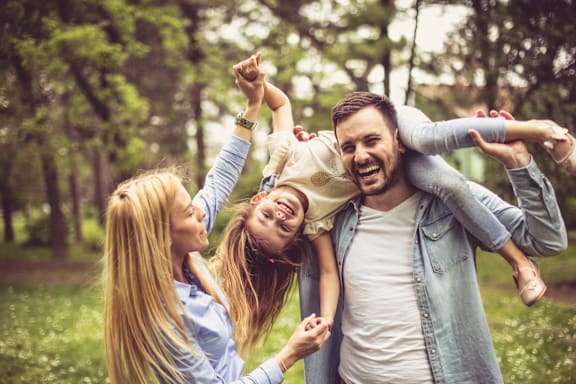 A man and two young girls are having fun in a park.