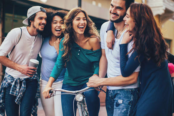 A group of friends are standing together and laughing.