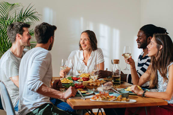 A group of people are sitting around a table enjoying a meal together.