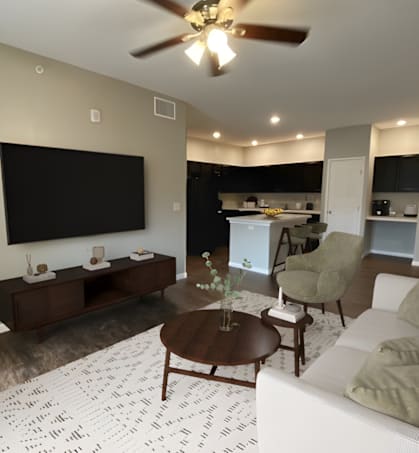 A living room with a white couch, a coffee table, and a flat screen TV mounted on the wall.