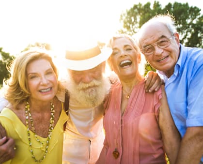 Four people posing for a photo in a field.