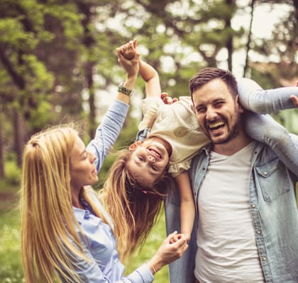 A man and two young girls are having fun in a park.