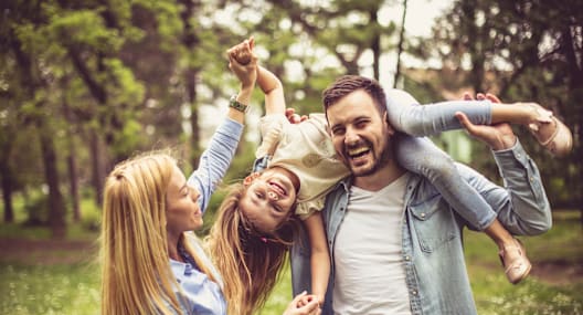 A man and two young girls are having fun in a park.
