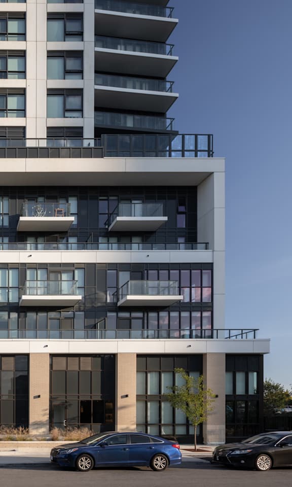 A modern building with a glass facade and a car parked in front.