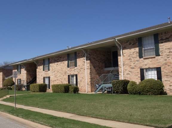 a row of brick apartment buildings on the side of a street at Archer Village Apartments,Sherman, TX,