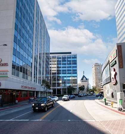 A city street with cars and buildings on either side.