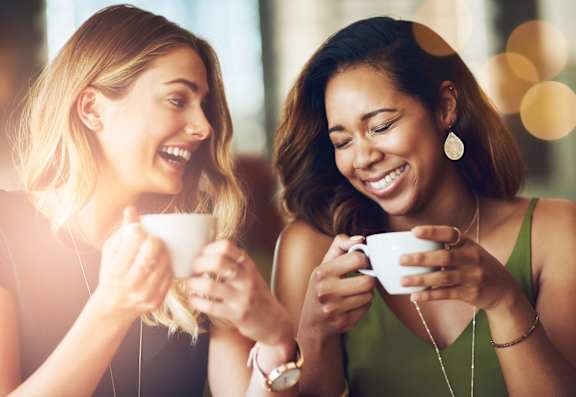 two women drinking coffee in a cafe
