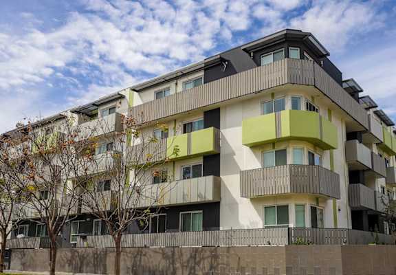 a picture of an apartment building with yellow balconies
