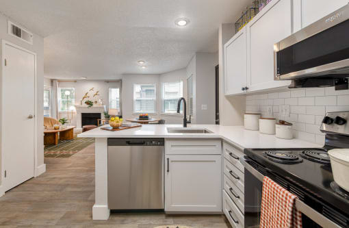 a kitchen with white cabinets and a white counter top and a sink
