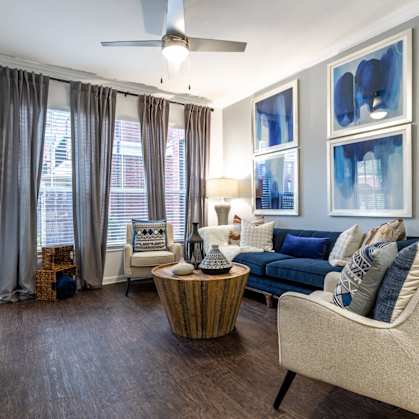 a living room with blue and white furniture and a ceiling fan
