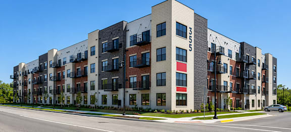 Modern apartment building exterior with balconies and street view at Panton Mill Apartments in Illinois