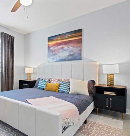A bedroom with a large bed and a ceiling fan.at Elan Apartments, Fort Walton Beach, FL