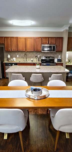 A kitchen with a table and chairs in the foreground.
