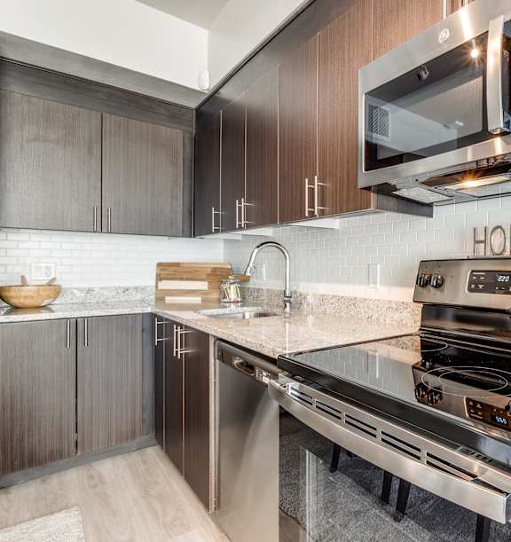 A modern kitchen with a stainless steel oven and wooden cabinets.