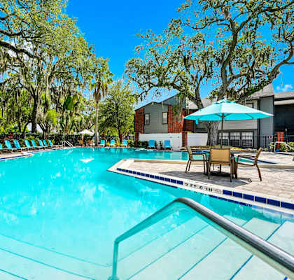 our apartments have a swimming pool with chairs and umbrellas
