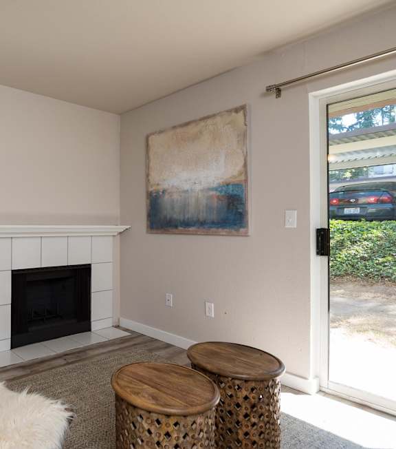 A living room with a fireplace and a painting on the wall.