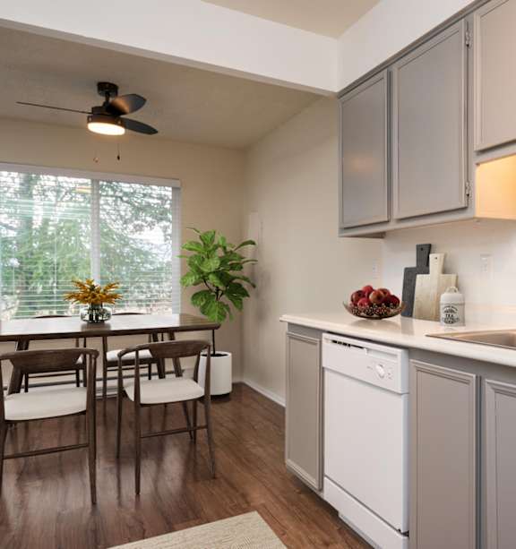 A kitchen with a table and chairs by a window.