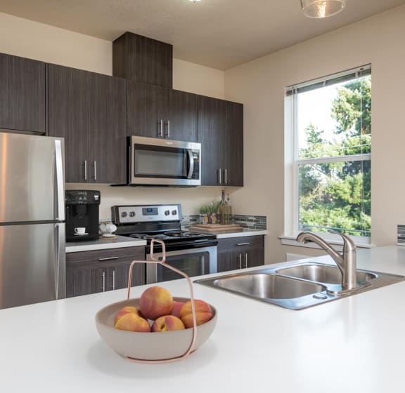 a kitchen with stainless steel appliances and a bowl of fruit