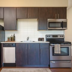 a kitchen with dark cabinets and stainless steel appliances