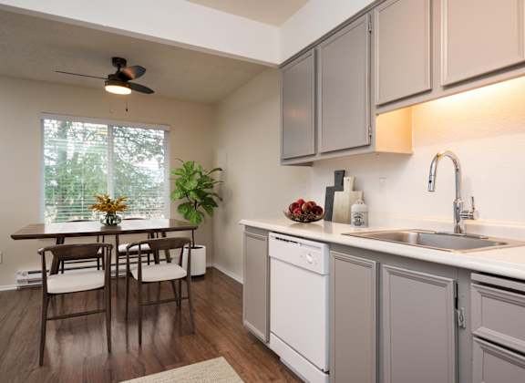 A kitchen with a table and chairs by a window.