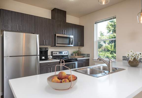 a kitchen with stainless steel appliances and a bowl of fruit